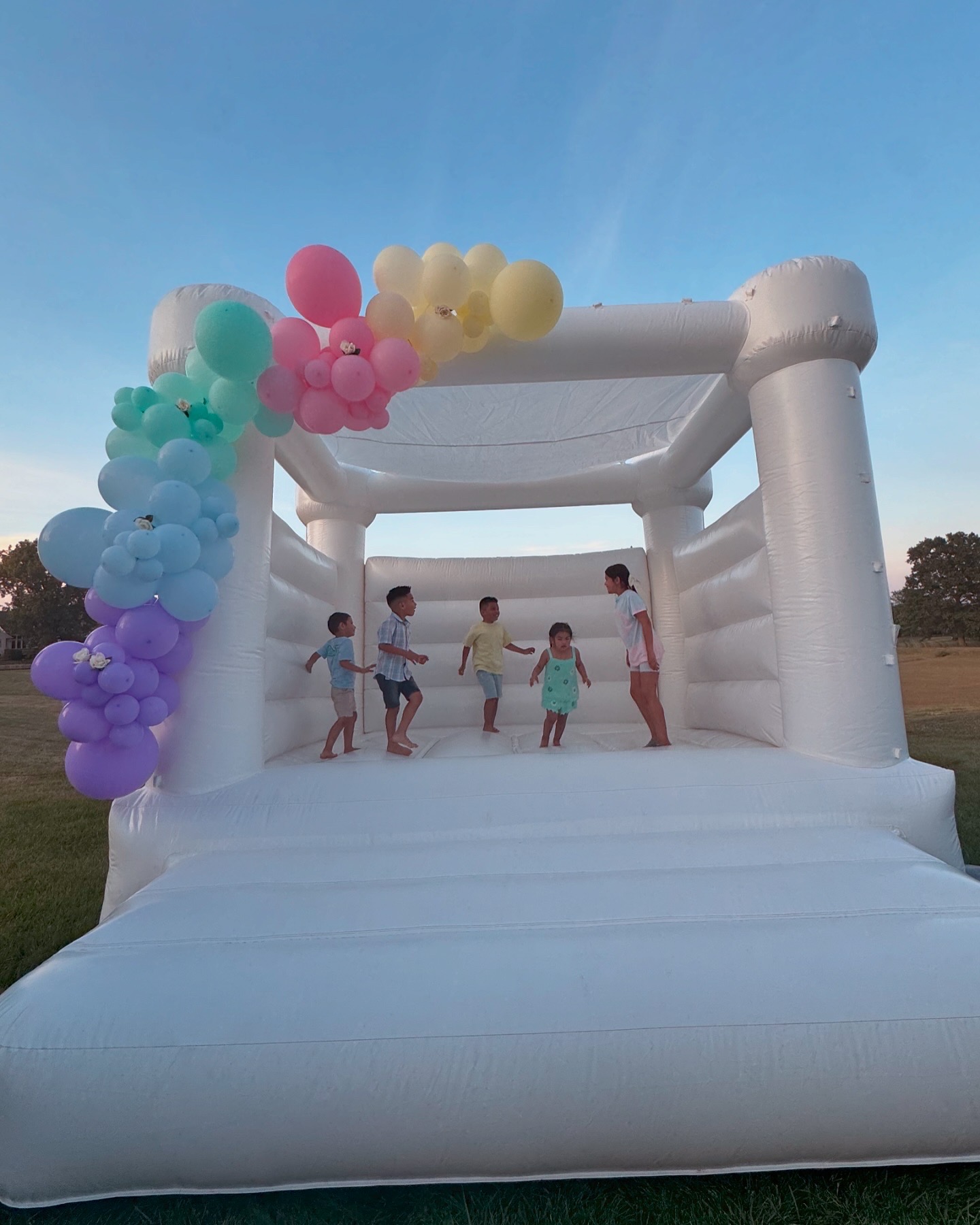 Children playing inside a clean white bounce house rental in Fort Wayne Indiana