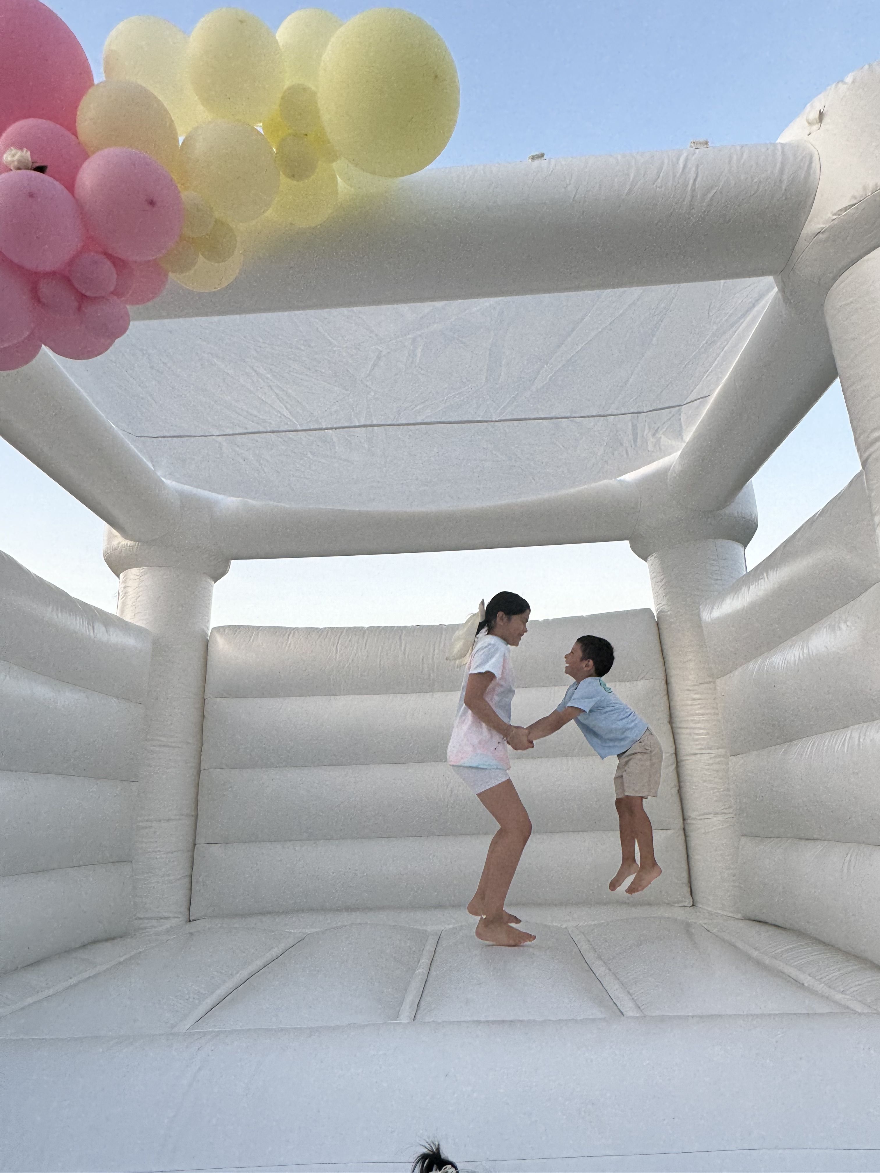 Children enjoying a white bounce house rental at an outdoor event in Fort Wayne Indiana