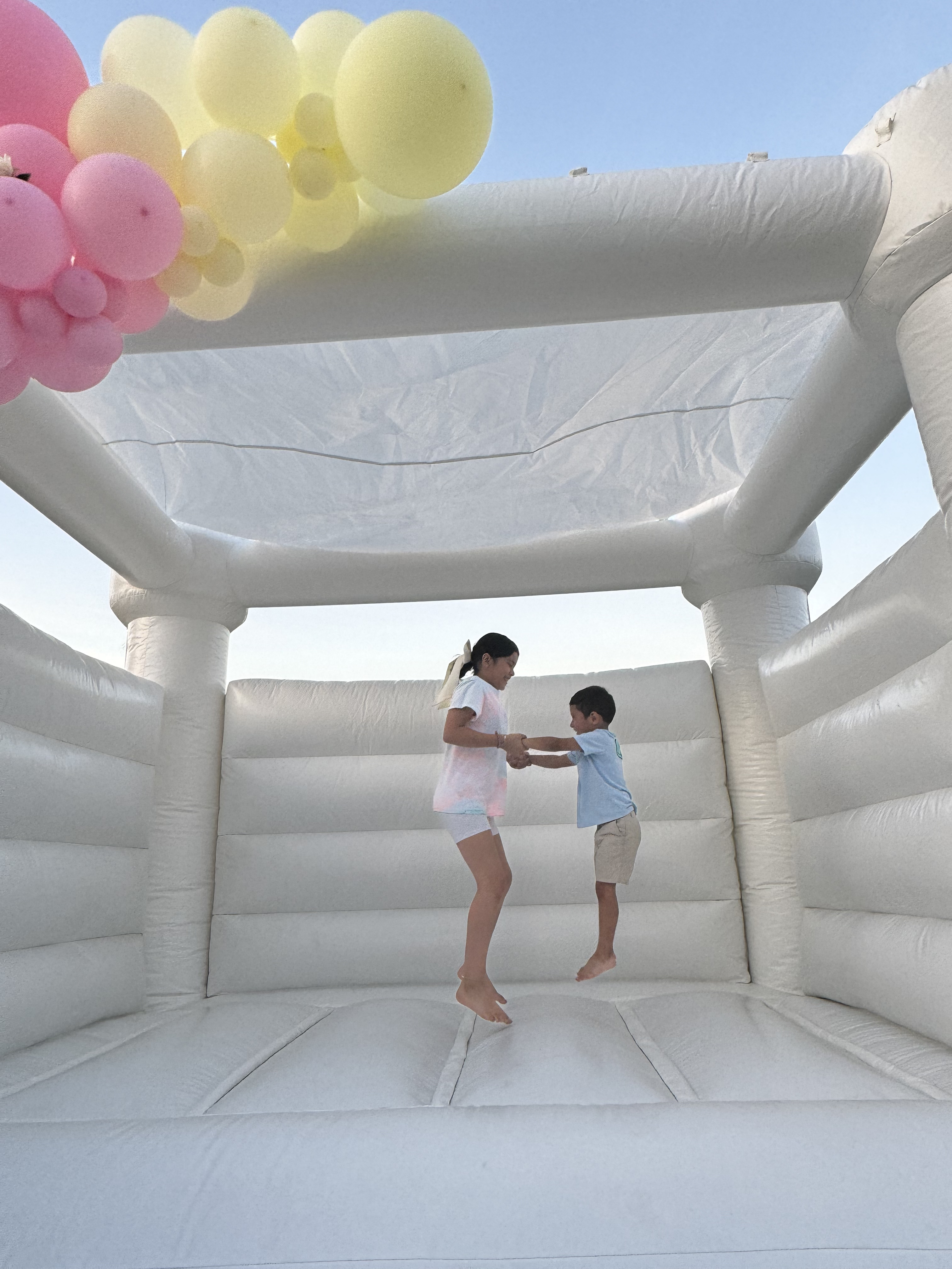 Kids jumping in a white bounce house rental at a Fort Wayne birthday party