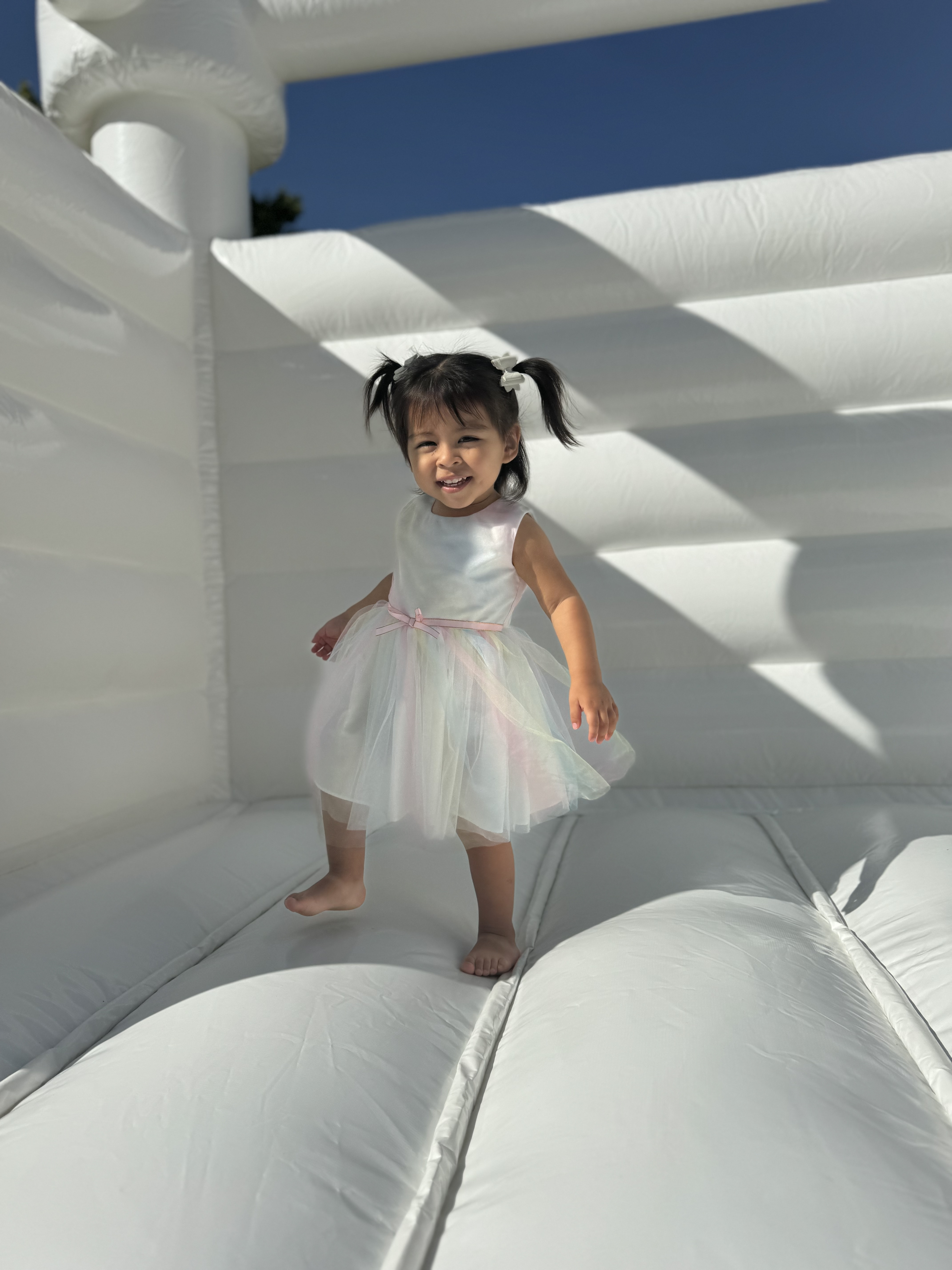 Young child enjoying a white bounce house rental in Fort Wayne Indiana